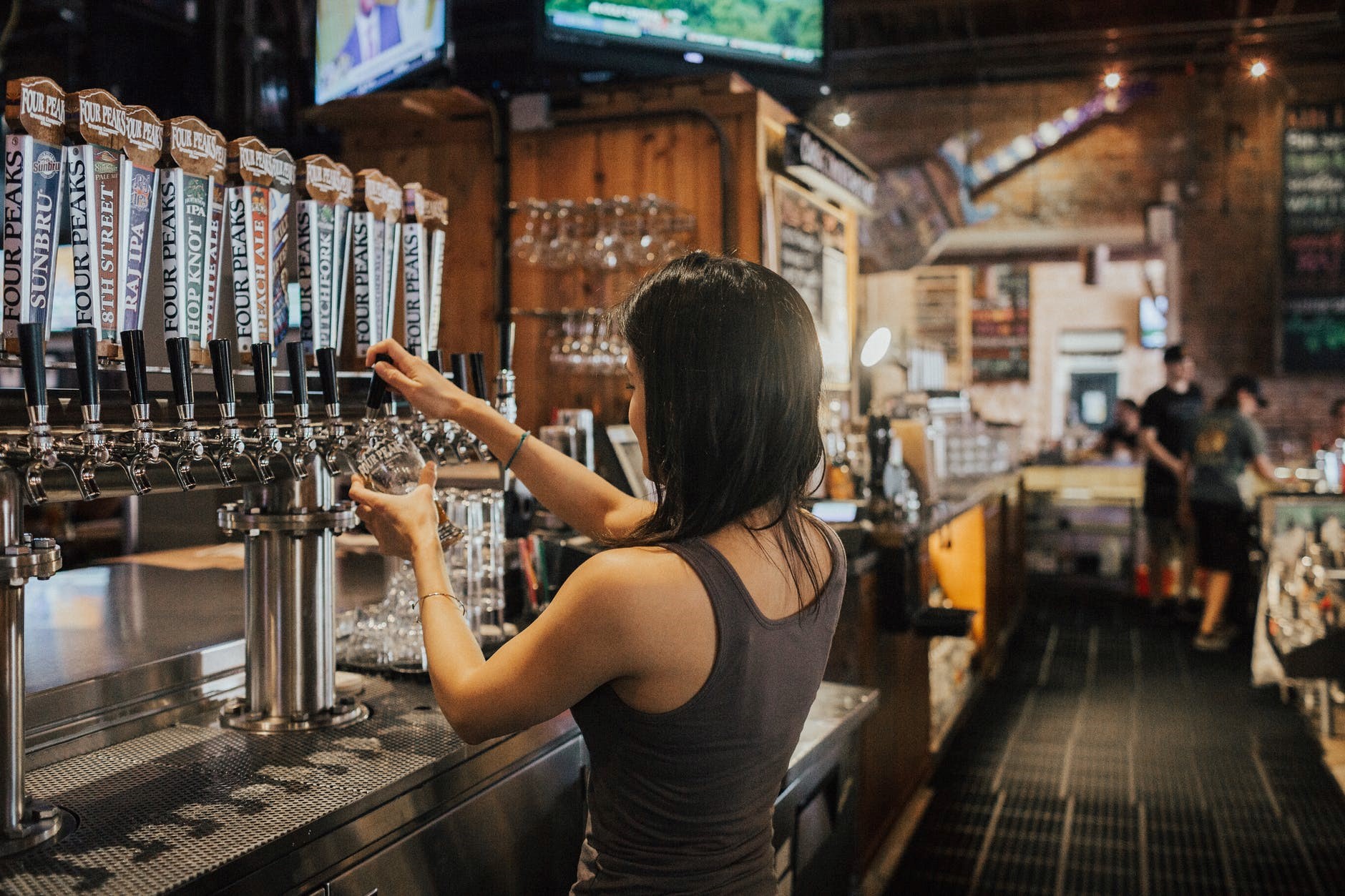 woman pulling a pint in a pub