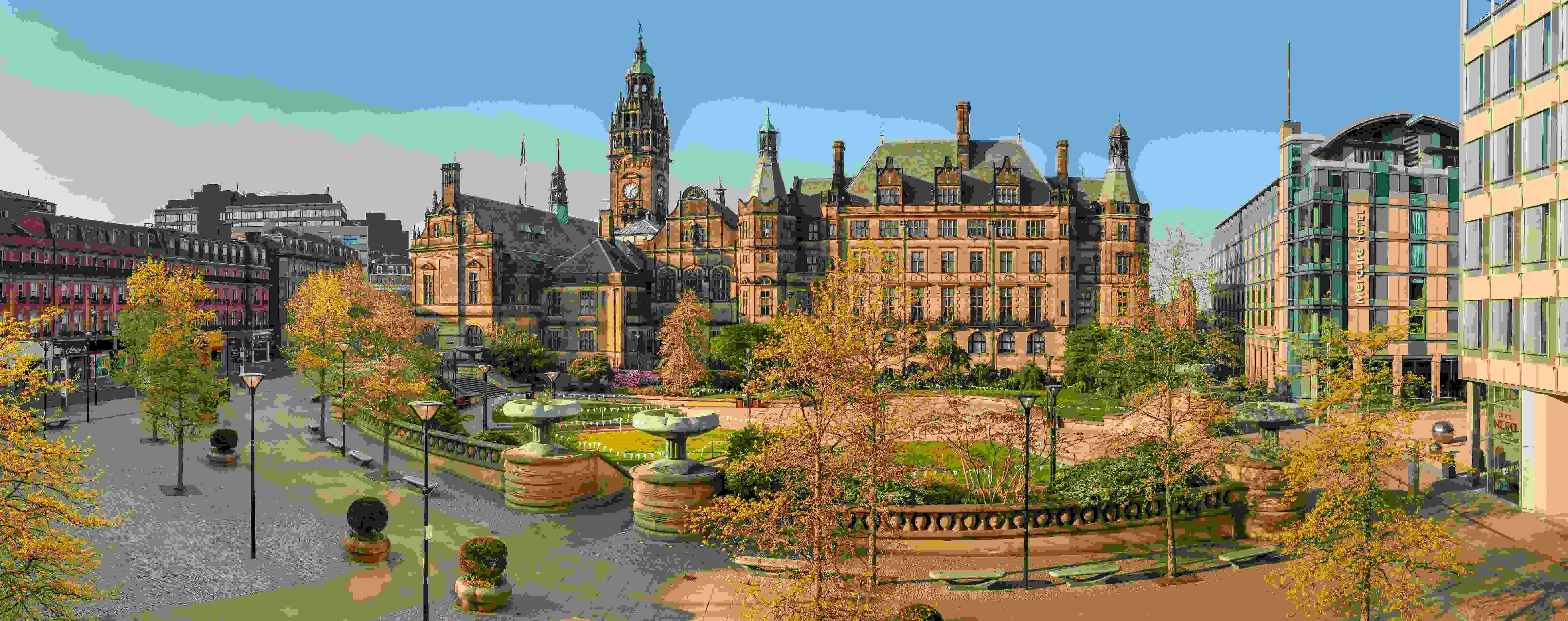 A panoramic picture of the Sheffield Town Hall and Peace Gardens at dusk