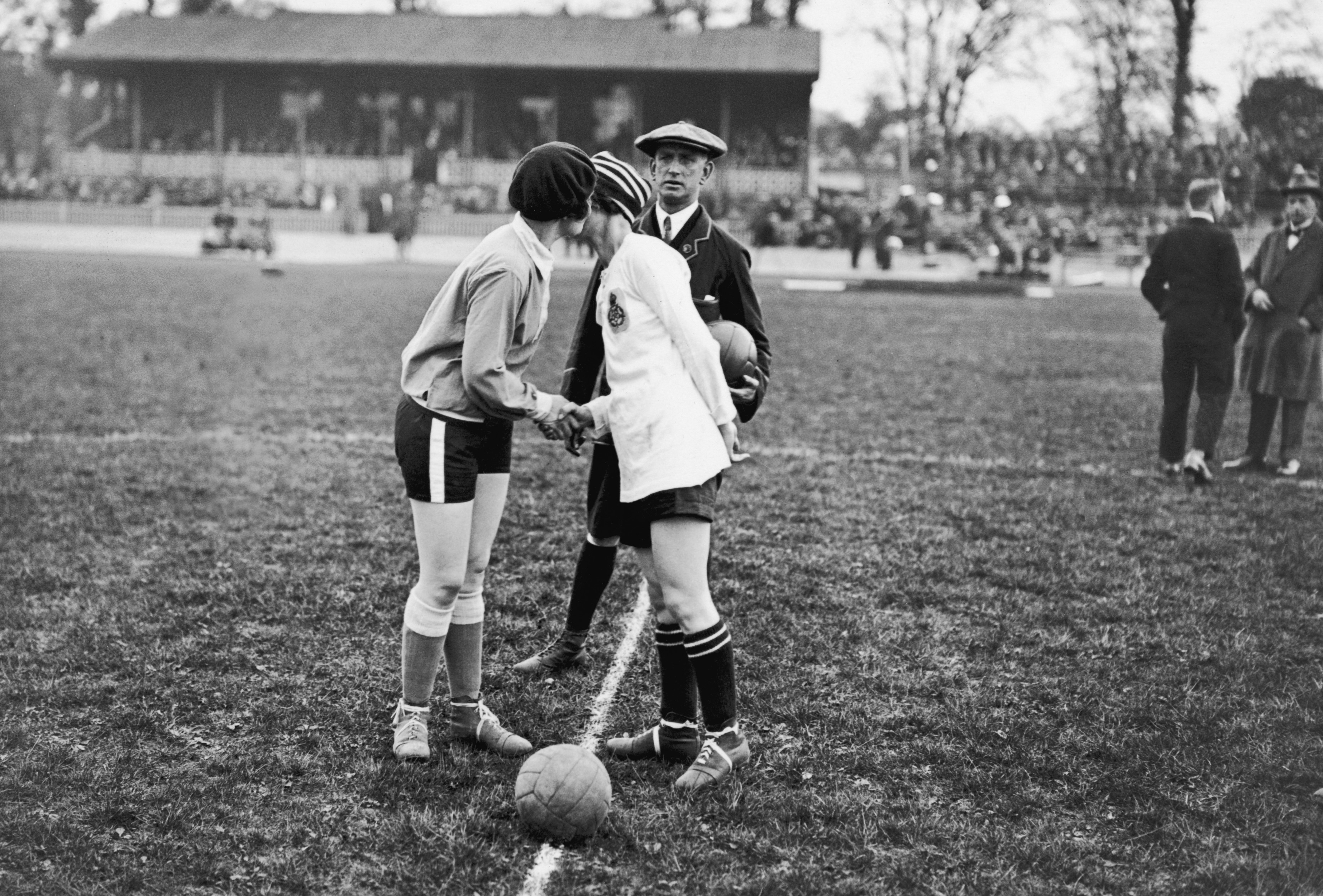 Two women kiss before kick off in an old football match