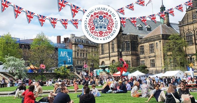 Peace Garden, Sheffield with people sat on the grass and the 'King Charles III Coronation' emblem over the top, infront of the Town Hall