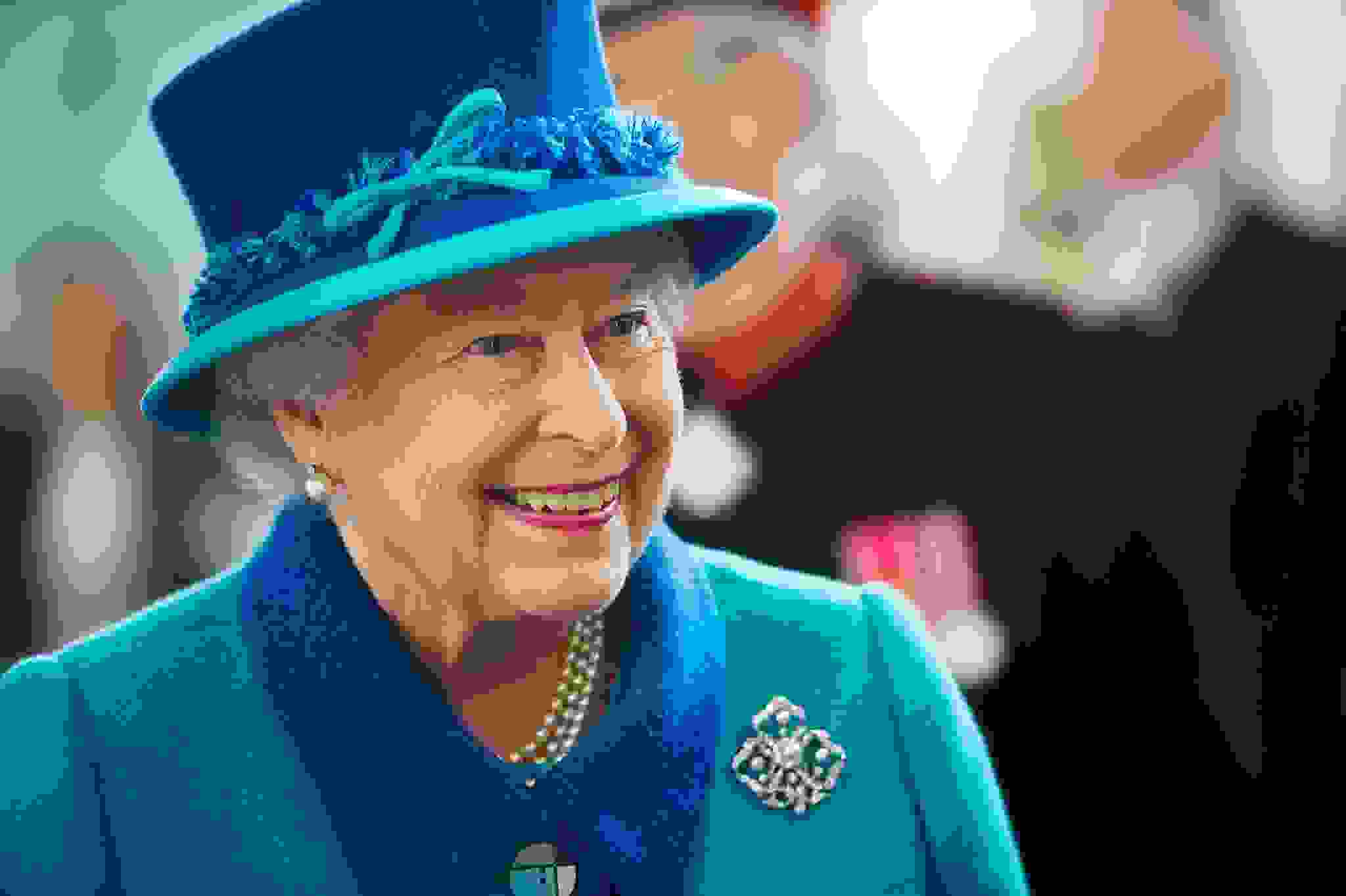 Her Majesty Queen Elizabeth ll smiling in blue coat with darker blue collar and matching hat