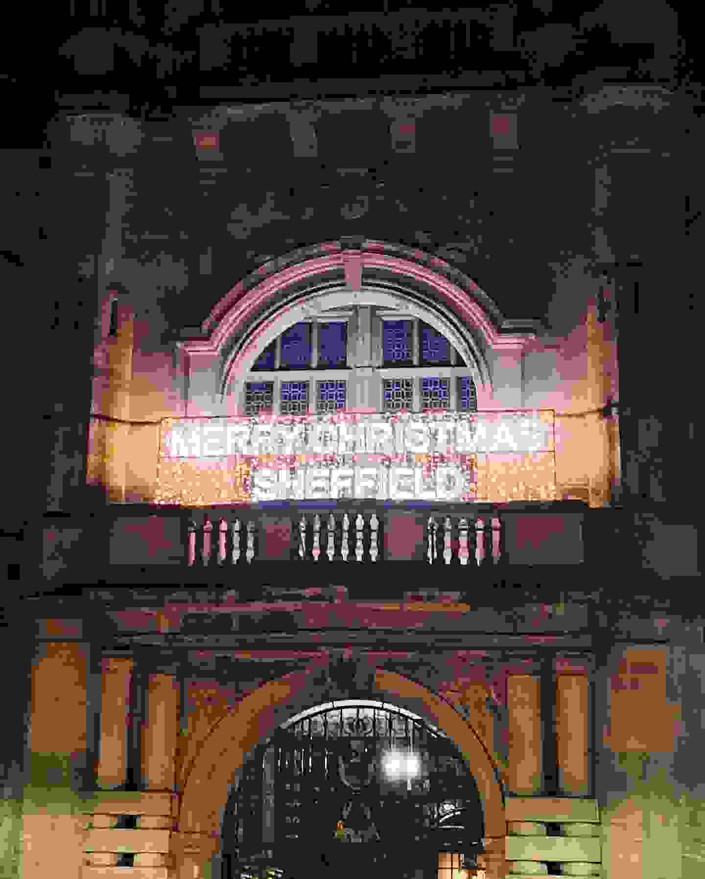"Merry Christmas Sheffield" written in lights across the front of the town hall