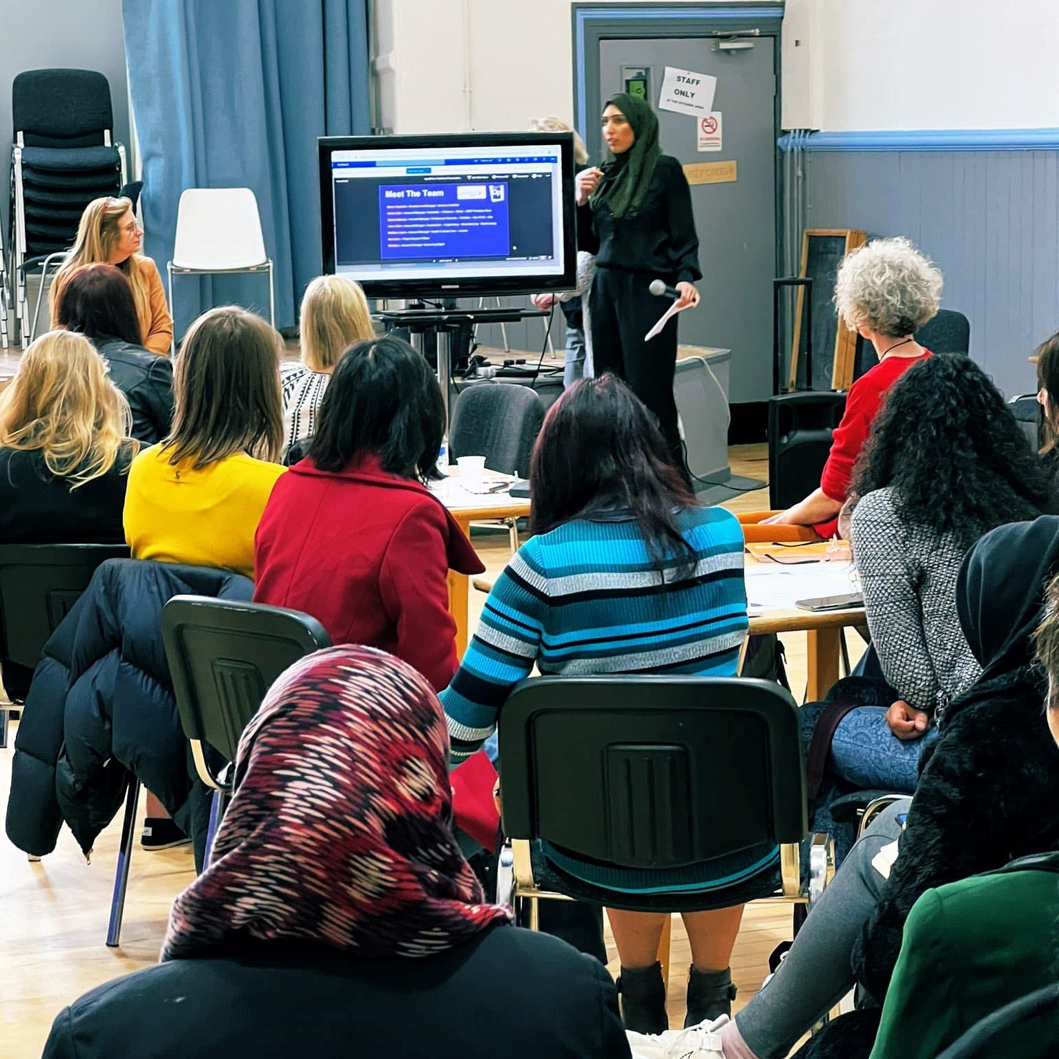 A group of people watching a presentation at a women’s networking event.