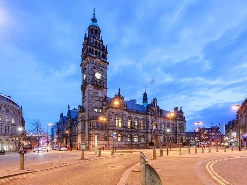 Sheffield Town Hall is lit up as the sun sets in the city