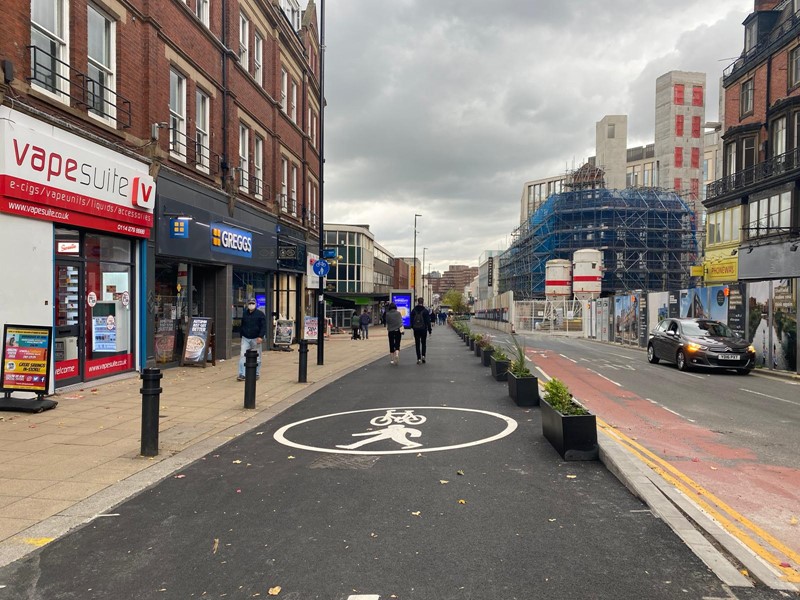 Pavement widened with tarmac, lined with planters