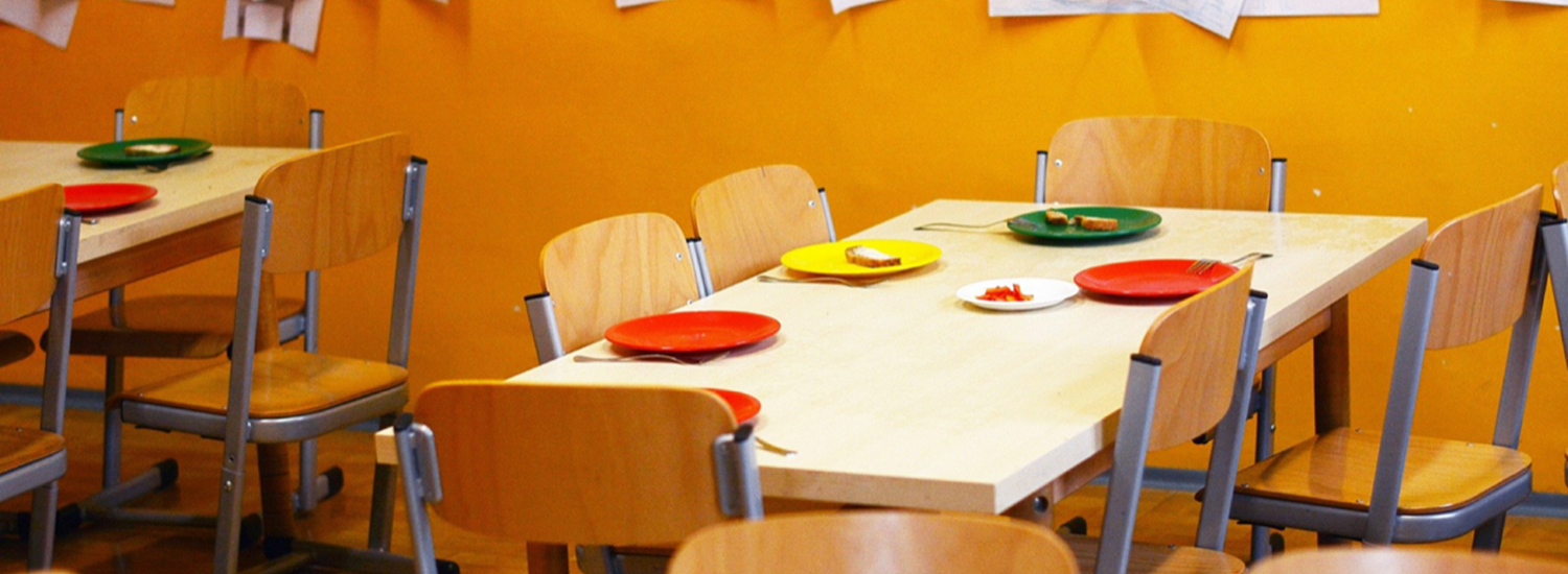 School canteen with red an yellow plastic plates on the tables