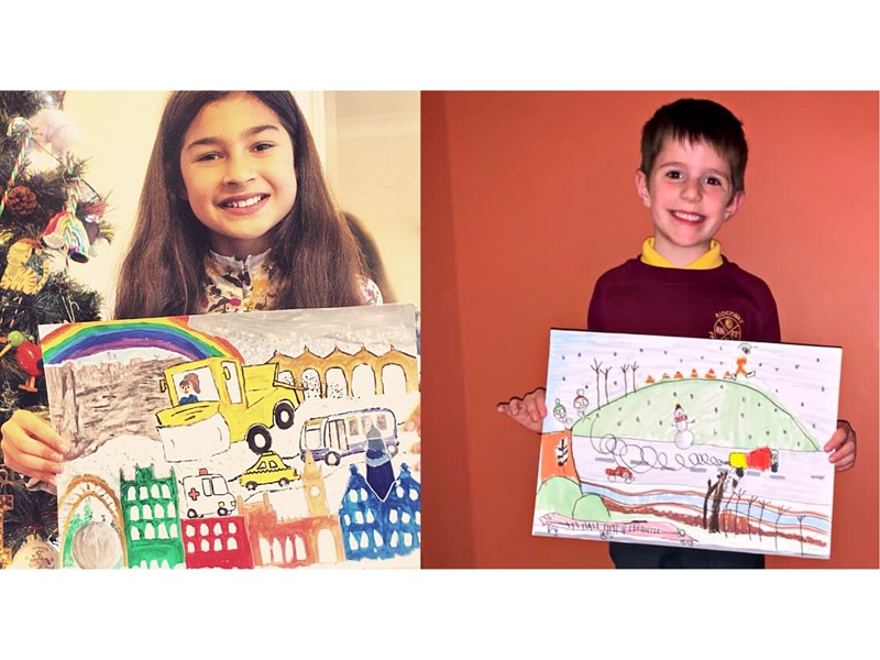 Two children hold up winning winter gritter designs on paper