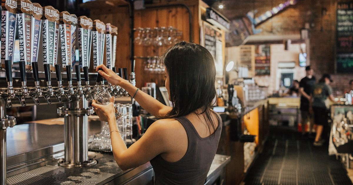 woman pulling a pint in a pub