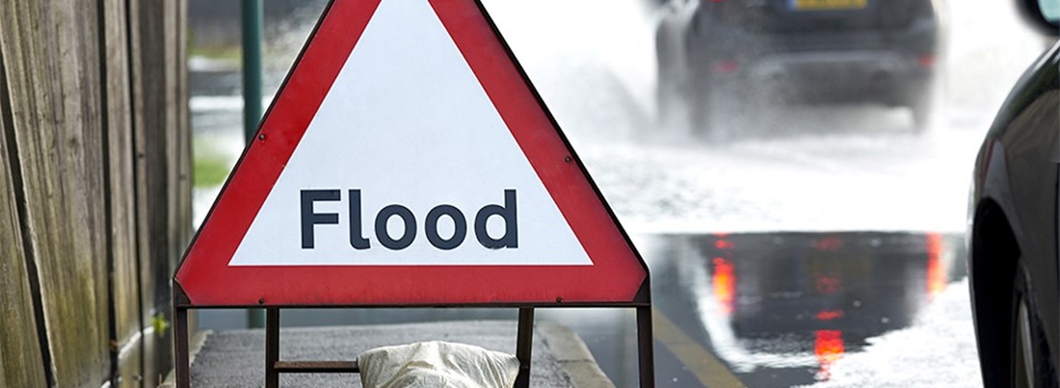 Triangle sign with red border saying flood