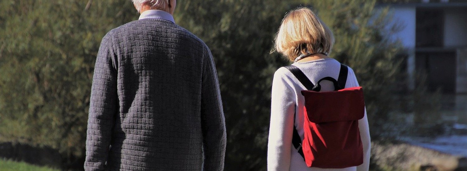 Older man walking with woman outdoors