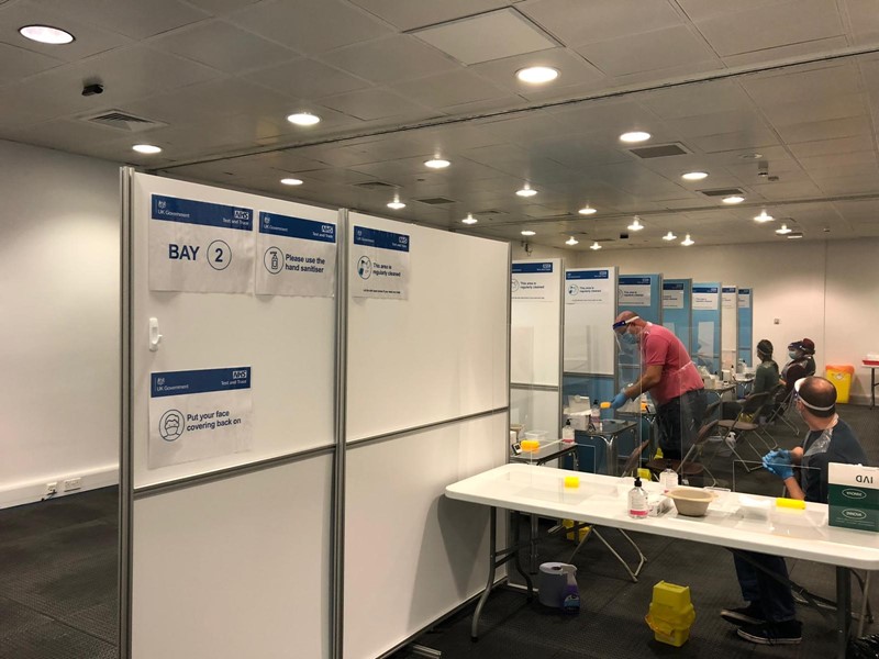 Inside English Institute of Sport asymptomatic testing centre with tables, people and testing equipment on show