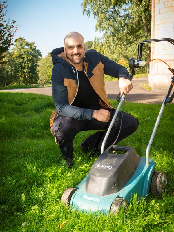Man with mower in a grassed garden