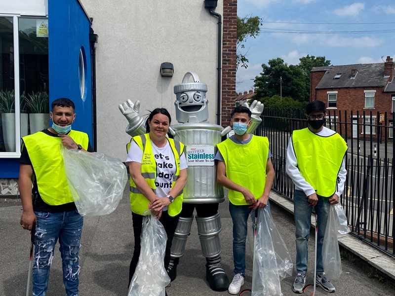 4 people stood outside with litter bags 