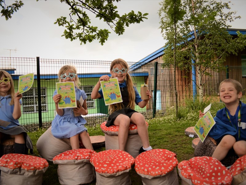 Children outside Watercliffe Meadow Primary holding reading challenge flyers