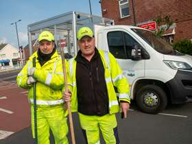 Two men in high visibility jackets standing in front of van