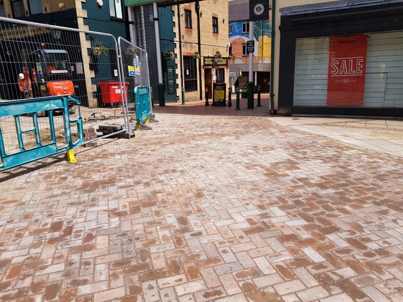 Paving slabs surrounded by shops and barrier