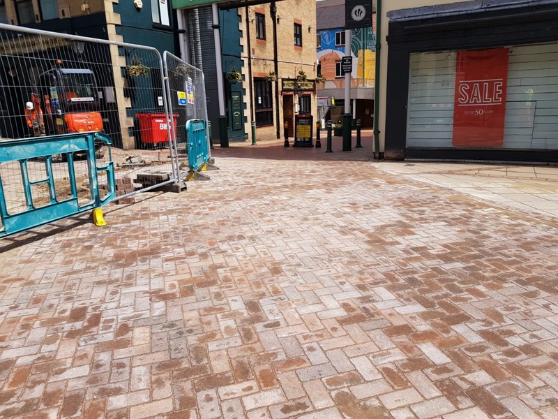 Paving slabs surrounded by shops and barrier