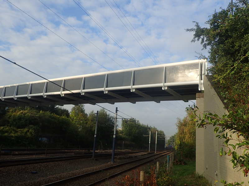 Metal footbridge with blue and cloudy sky background