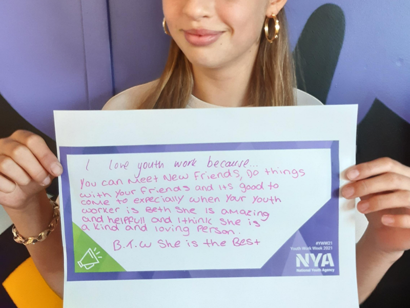 Young girl holding a sign saying I love Youth Work