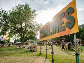 Tramlines sign with trees and people in background Tramlines sign with trees and people in background