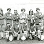 women's football team standing by goal posts