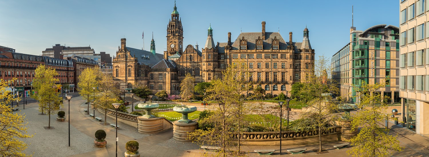 A panoramic picture of the Sheffield Town Hall and Peace Gardens at dusk