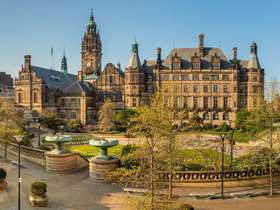 A panoramic picture of the Sheffield Town Hall and Peace Gardens at dusk