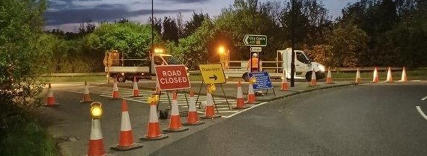 Cones and road closed sign next to street light