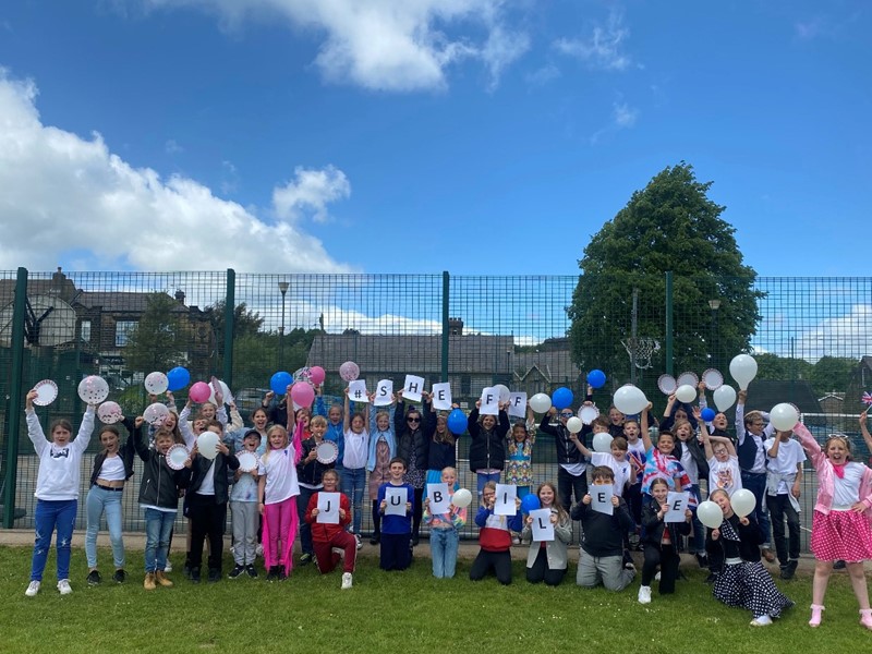 Grenoside Primary children holding letters in the air to celebrate Jubilee