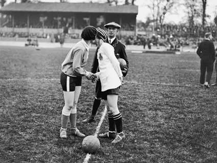 Two women kiss before kick off in an old football match