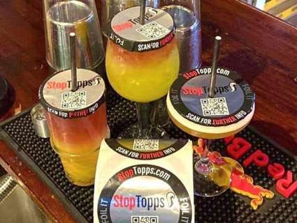 Drinking glasses with straws on a bar with secure toppers 