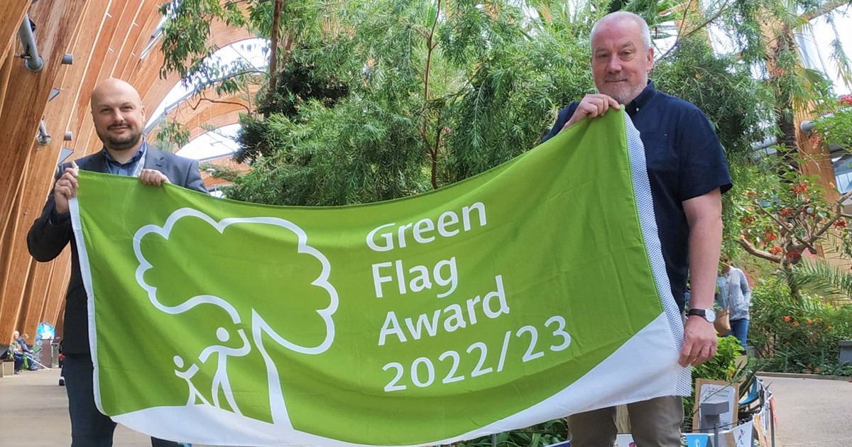 Liam Pond stands with Councillor Richard Williams, proudly holding the Green Flag award in Sheffield Winter Garden