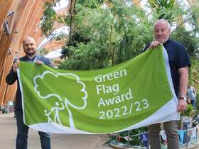 Liam Pond stands with Councillor Richard Williams, proudly holding the Green Flag award in Sheffield Winter Garden