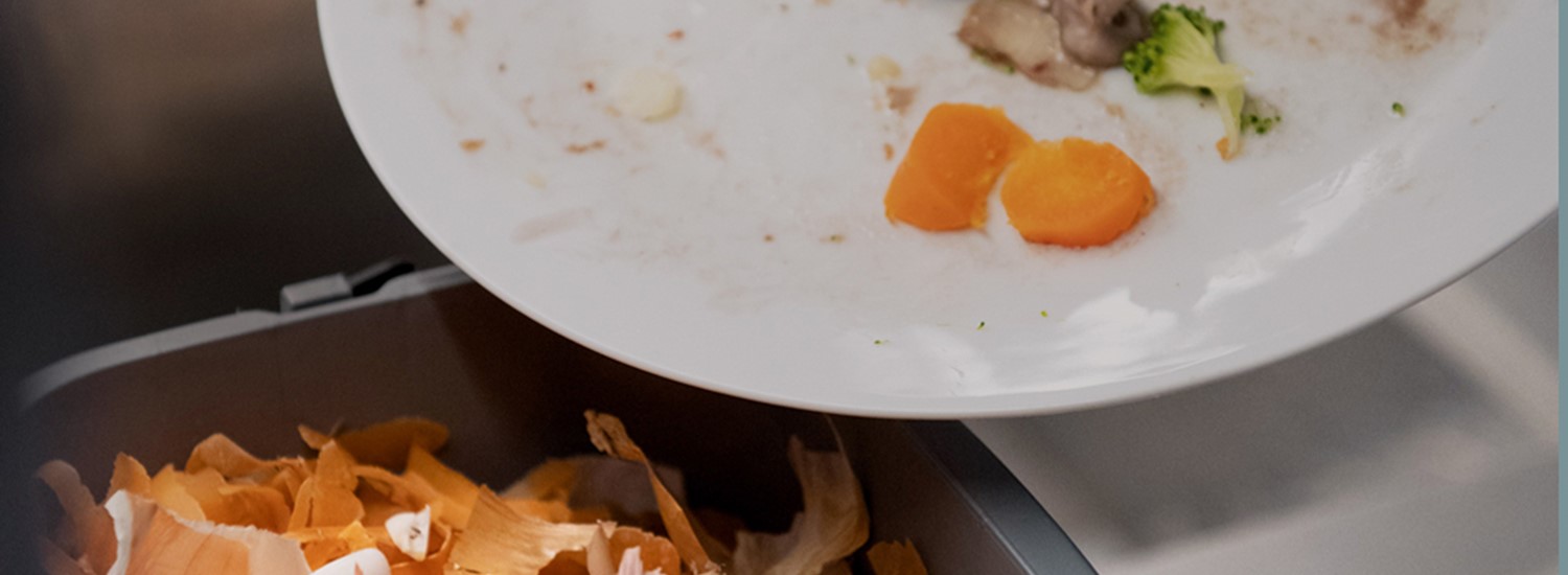 Food waste on white plate being scraped with knife