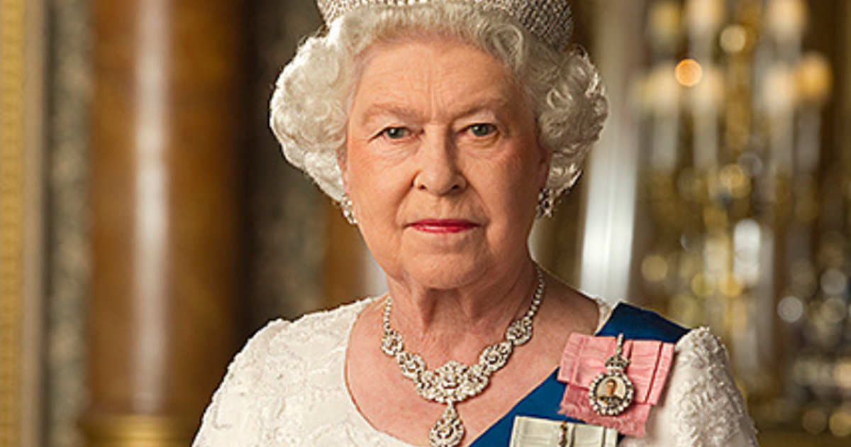 A image of Her Majesty, Queen Elizabeth wearing a white dress, a blue sash and a crown