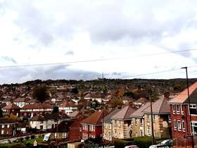 Rows of houses at Southey Green with grey sky looking over the valley 