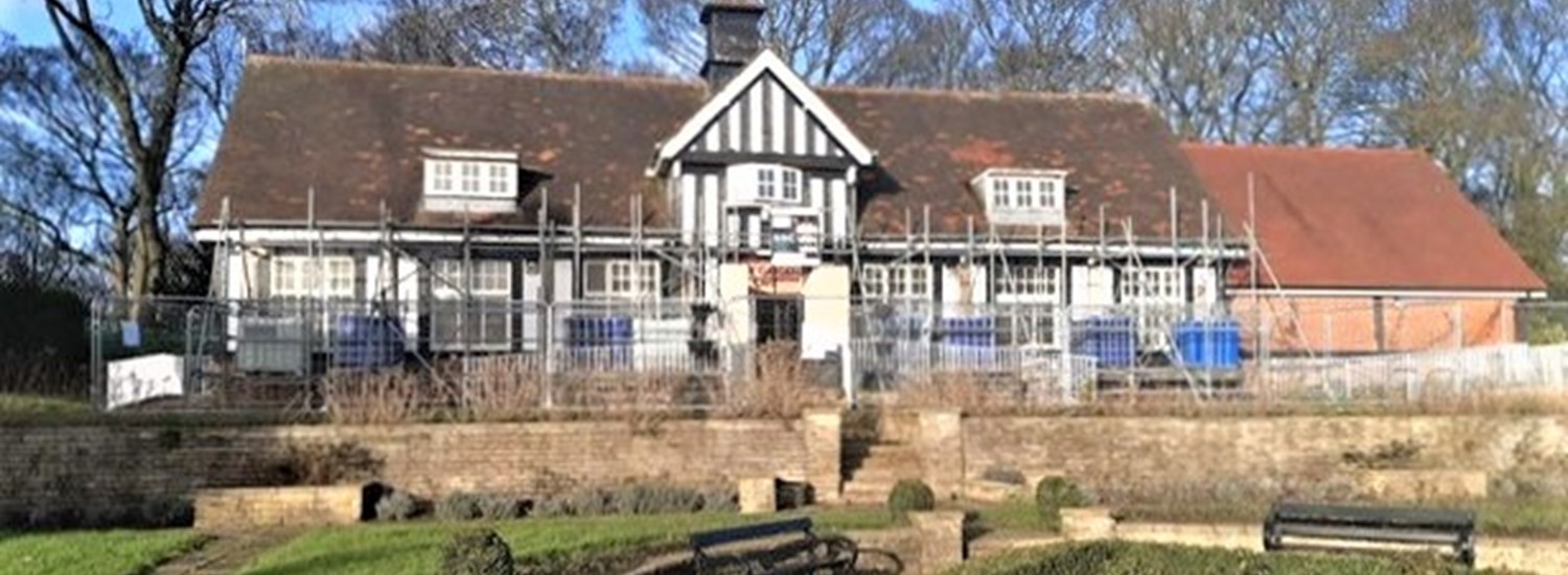 Cafe building with scaffold propping to the exterior, a garden is in front