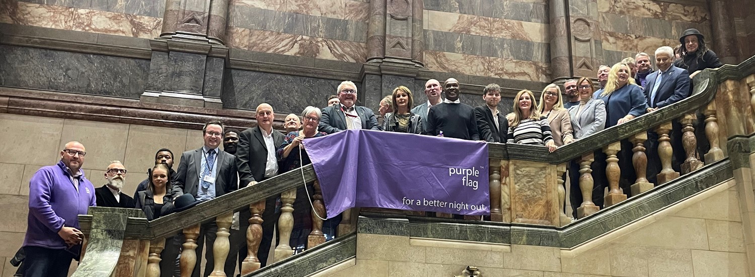 Number of people stood on the town hall steps, showing a banner that says 'purple flag, for a better night out'