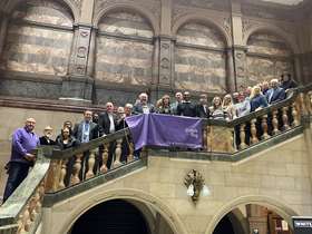 Number of people stood on the town hall steps, showing a banner that says 'purple flag, for a better night out'