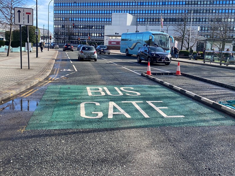 A green bus gate road marking