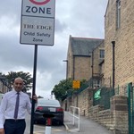 More schemes approved for Sheffield’s roads and neighbourhoods Cllr Mazher Iqbal next to a road sign that says '20 zone'