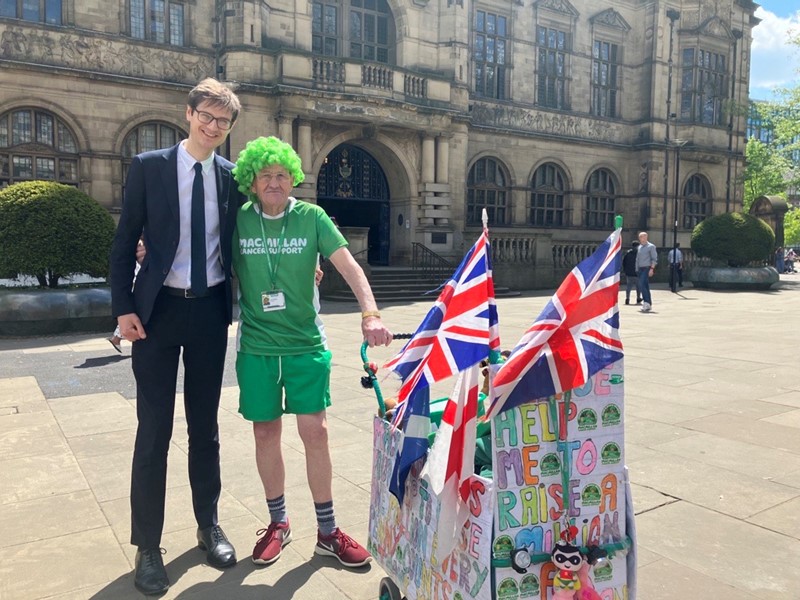 Councillor Tom Hunt and John Burkhill wearing his green wig, and pushing his pram, outside Sheffield Town Hall