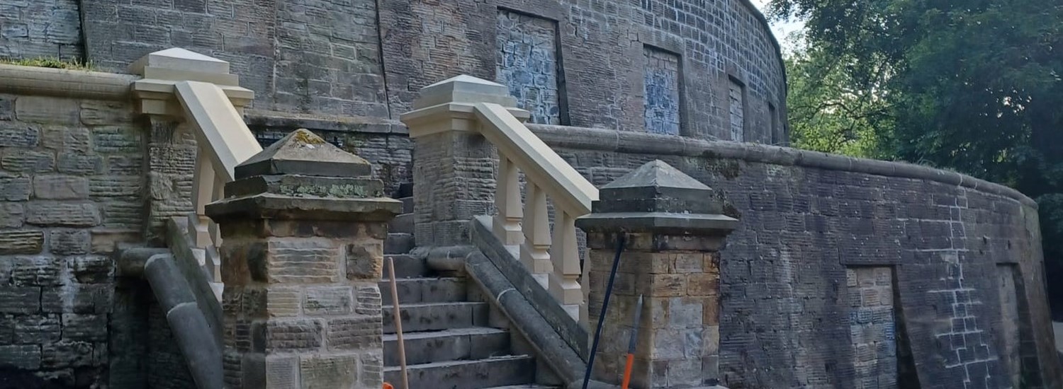 200 year old curved stone walls and catacombs with two pillars at the side of a flight of stone steps