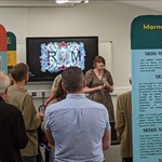 group of people in a meeting room discussing the Marnock Exhibition