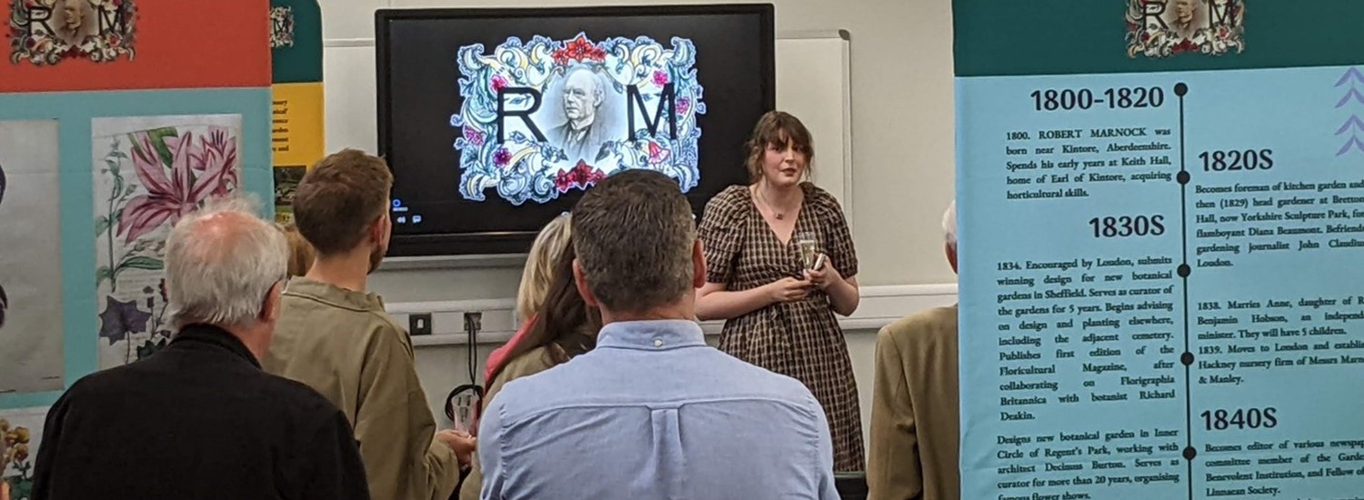 group of people in a meeting room discussing the Marnock Exhibition