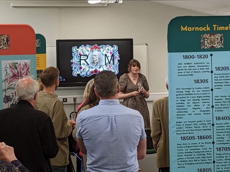 group of people in a meeting room discussing the Marnock Exhibition