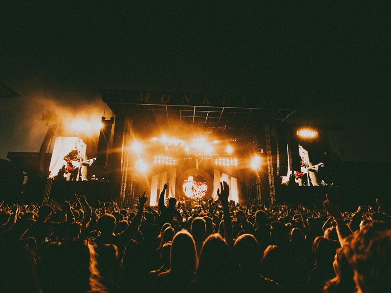 Arctic Monkeys live on stage with the crowd infront - photo credit Lewis Evans