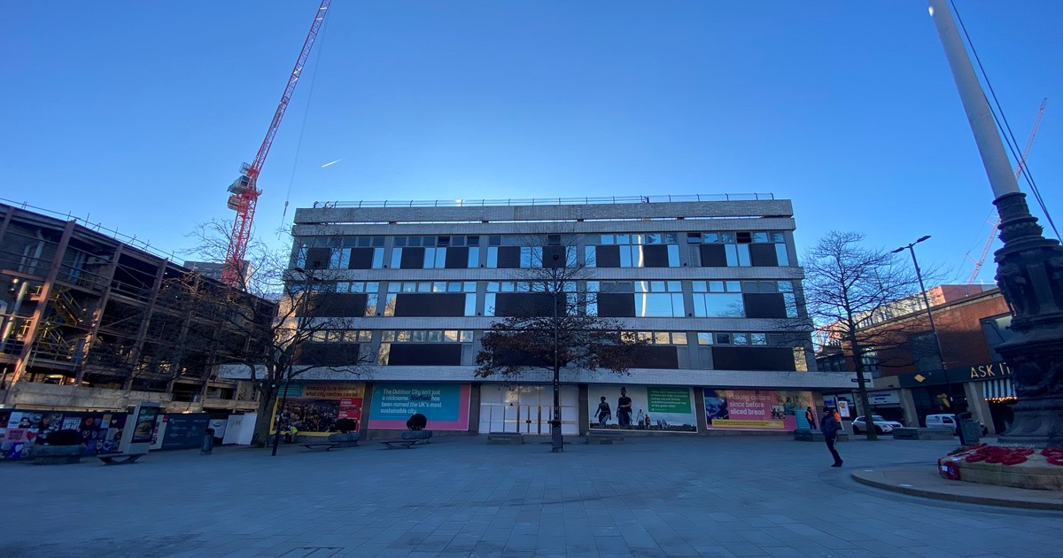 Cole Brothers building stands beside a crane and blue skies