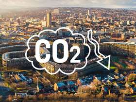A drone shot of Sheffield city centre with a graphic over the top which says CO2 with a downward arrow.