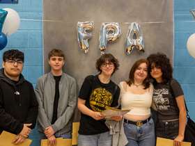5 Students facing the camera with FPA balloons behind them